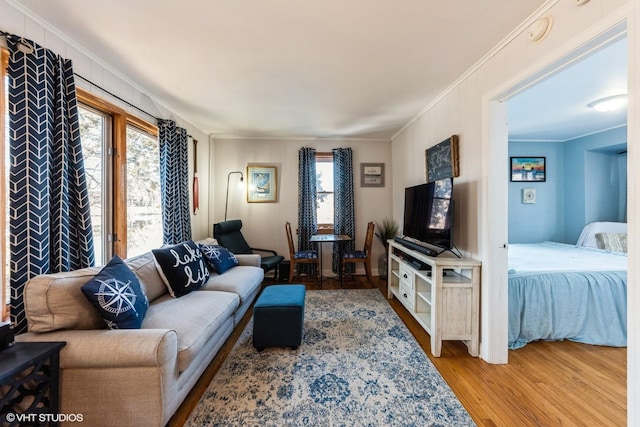 living area with crown molding and light wood-type flooring