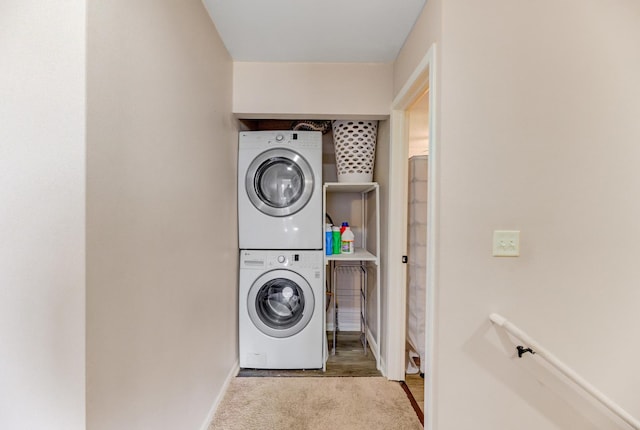 laundry room featuring baseboards, laundry area, carpet floors, and stacked washer / drying machine