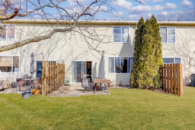 rear view of house featuring a patio area, fence, and a yard