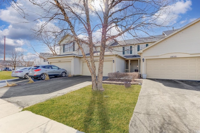 view of front of house with a garage, aphalt driveway, and a front lawn