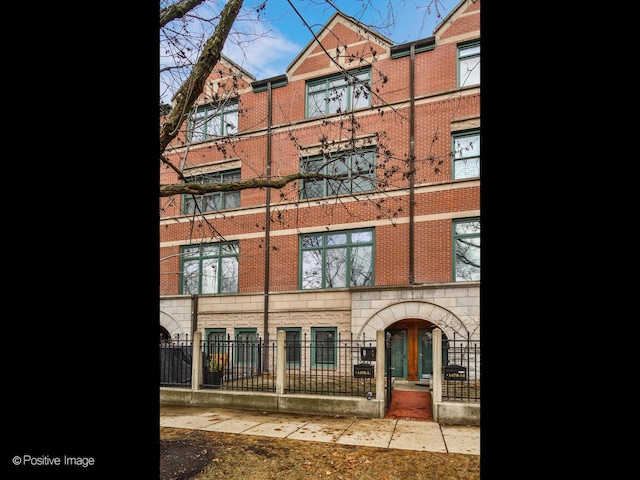 exterior space featuring a fenced front yard and brick siding