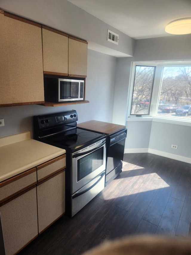 kitchen with baseboards, visible vents, dark wood finished floors, stainless steel appliances, and light countertops