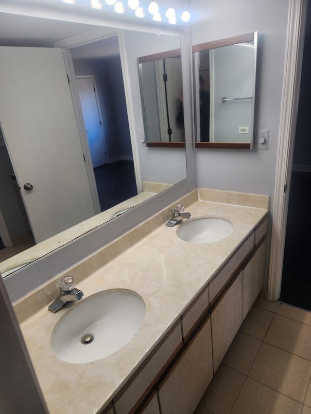 full bathroom with double vanity, a sink, and tile patterned floors