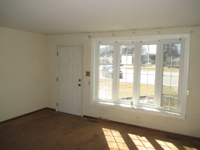 entryway with carpet flooring, visible vents, and baseboards