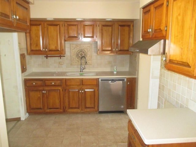 kitchen with stainless steel dishwasher, a sink, and brown cabinets