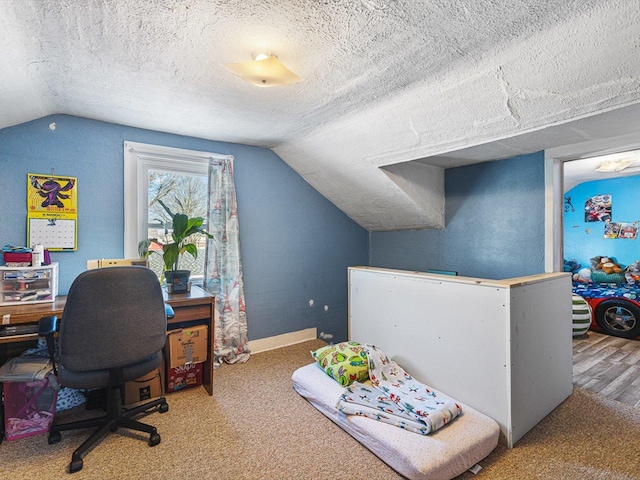 office space with a textured ceiling, vaulted ceiling, and baseboards