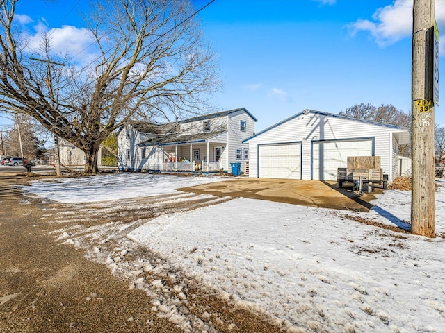 view of front of property featuring covered porch, a detached garage, and an outbuilding