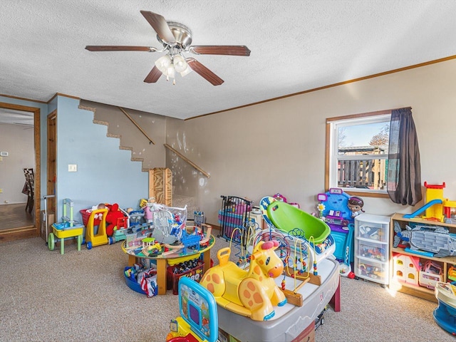 game room featuring a textured ceiling, ornamental molding, and carpet flooring