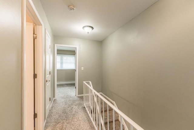 hall featuring light carpet, baseboard heating, an upstairs landing, and baseboards