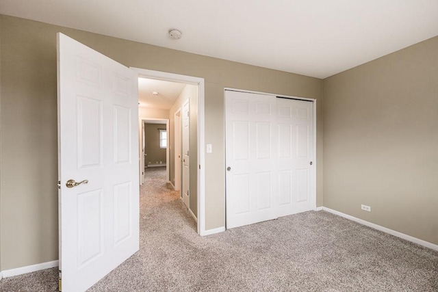 unfurnished bedroom featuring light carpet and baseboards