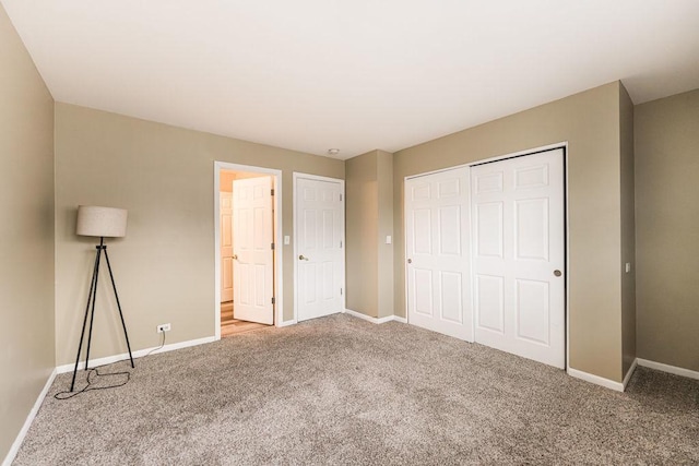 unfurnished bedroom featuring a closet, carpet flooring, and baseboards