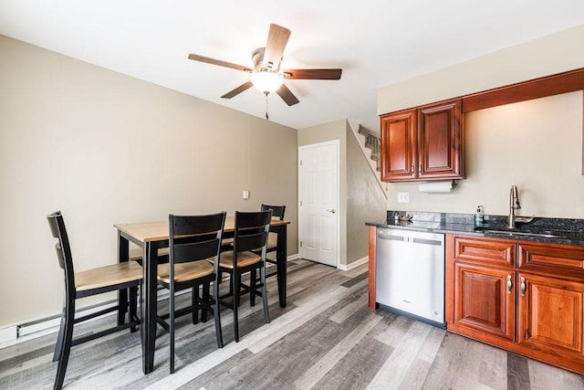 kitchen featuring stainless steel dishwasher, a sink, ceiling fan, light wood-type flooring, and baseboards