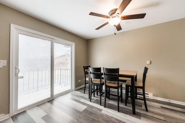 dining room featuring a ceiling fan, baseboards, and wood finished floors