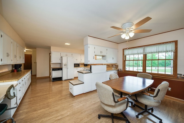 dining area featuring light wood-style flooring, ceiling fan, and baseboards