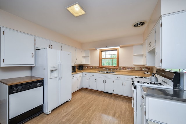 kitchen featuring white appliances, a sink, open shelves, and light wood-style floors