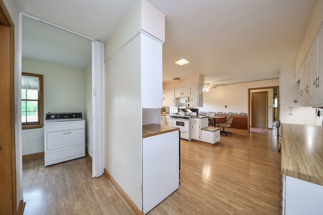 kitchen with washer / clothes dryer, white gas range oven, white cabinets, light wood-style flooring, and a ceiling fan