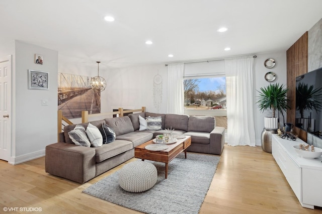 living room featuring light wood-type flooring, baseboards, an inviting chandelier, and recessed lighting