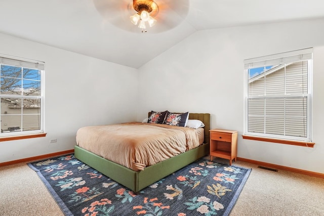 bedroom with lofted ceiling, baseboards, visible vents, and carpet