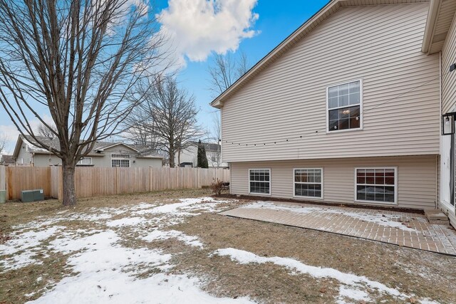 view of snowy exterior featuring a patio area and fence