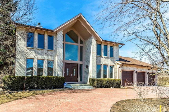 view of front facade featuring an attached garage, brick siding, and driveway