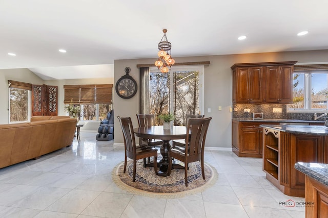 dining space with recessed lighting, a healthy amount of sunlight, and baseboards