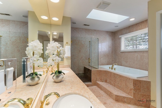 bathroom with a garden tub, a skylight, visible vents, and a stall shower