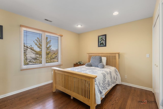 bedroom featuring visible vents, baseboards, and wood finished floors