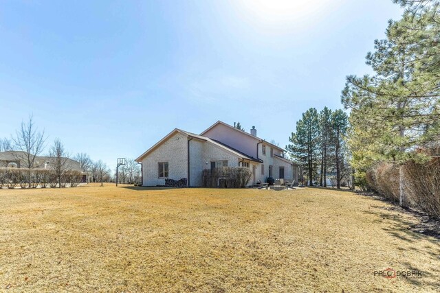 view of home's exterior with a lawn and a chimney