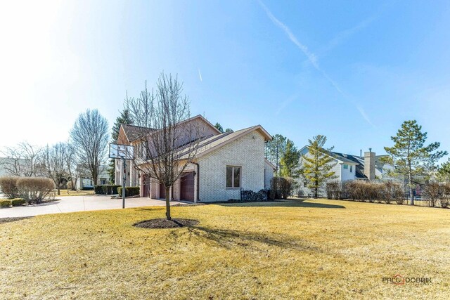 view of home's exterior with a garage, a lawn, concrete driveway, and brick siding