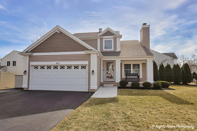 view of front of home featuring a front lawn, driveway, an attached garage, and fence