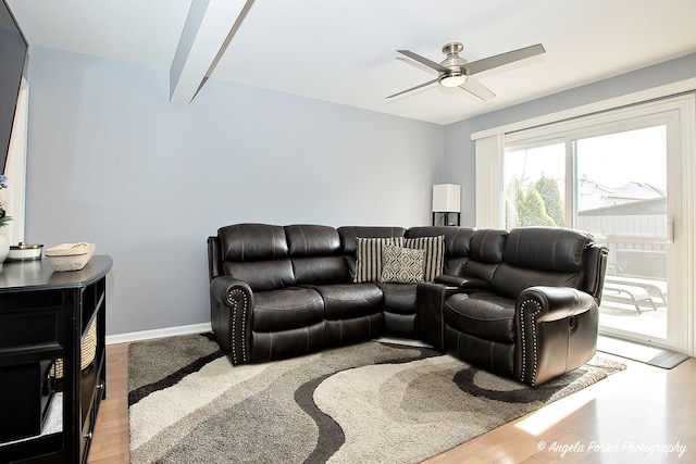 living room featuring ceiling fan, wood finished floors, beam ceiling, and baseboards