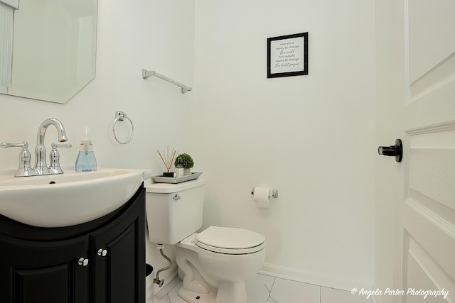 bathroom with baseboards, vanity, toilet, and tile patterned floors