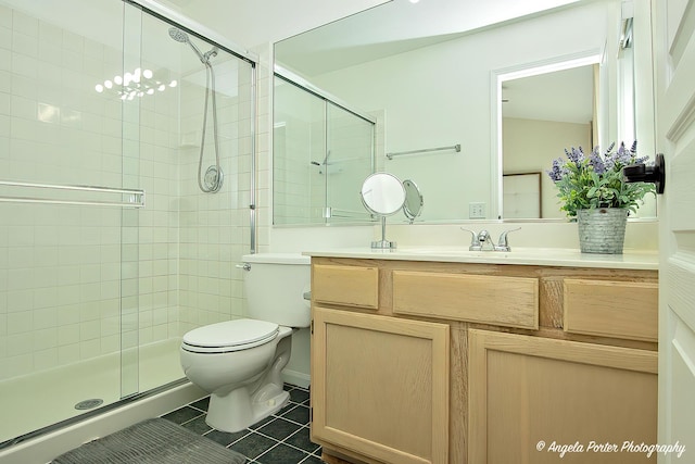 full bathroom featuring vanity, a stall shower, tile patterned flooring, and toilet