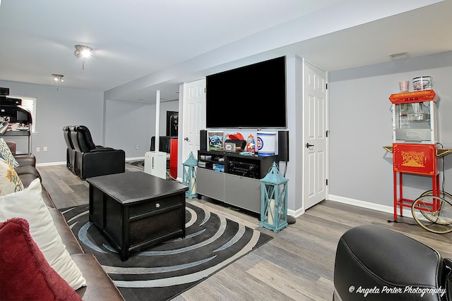 living area featuring visible vents, baseboards, and wood finished floors