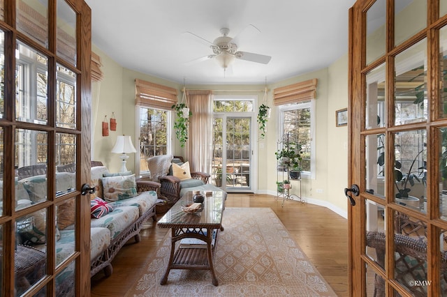 sunroom featuring a wealth of natural light, french doors, and a ceiling fan