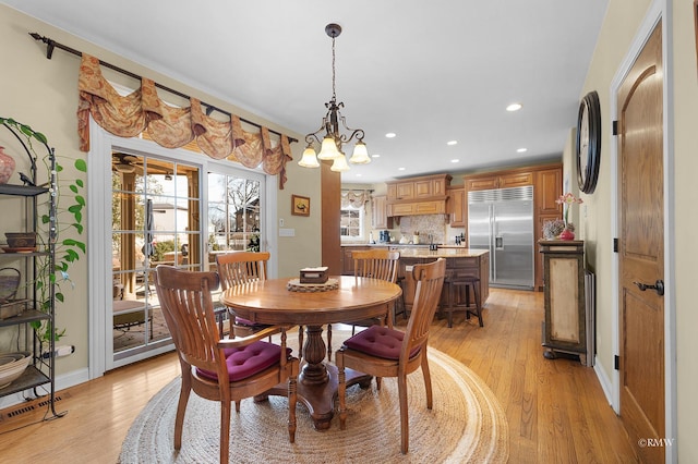 dining room with light wood finished floors, recessed lighting, and baseboards