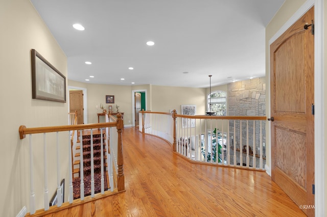 corridor featuring recessed lighting, an upstairs landing, and wood finished floors