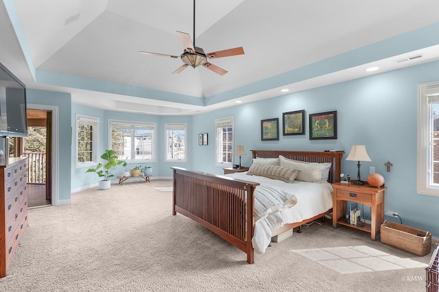 carpeted bedroom with visible vents, a ceiling fan, a tray ceiling, recessed lighting, and baseboards