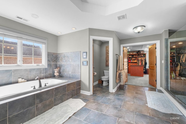 full bath featuring a spacious closet, visible vents, toilet, and a garden tub