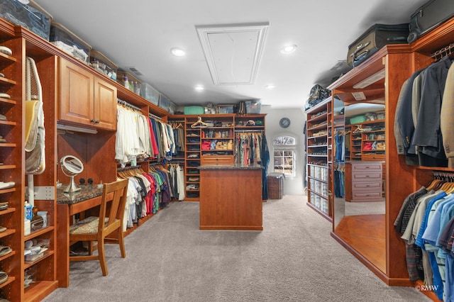 spacious closet with light carpet and attic access