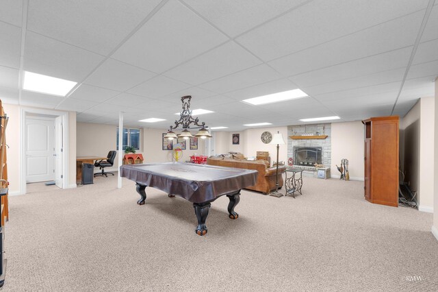 game room with carpet flooring, pool table, a stone fireplace, and a drop ceiling