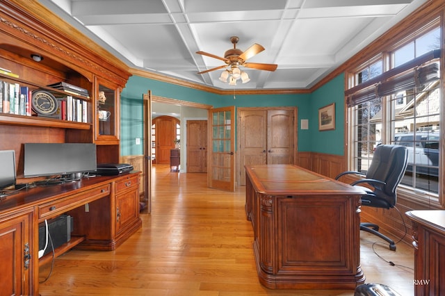 office featuring ceiling fan, a wainscoted wall, light wood-style flooring, arched walkways, and coffered ceiling