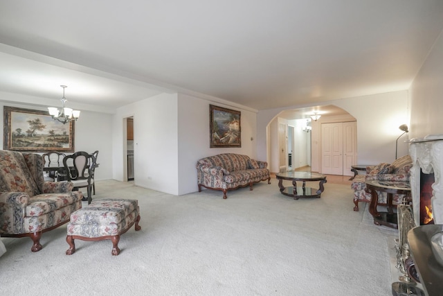 living room with light carpet, arched walkways, and a notable chandelier