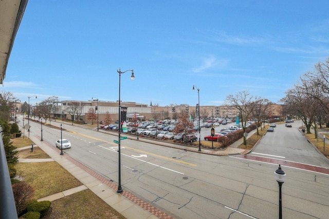 view of street featuring sidewalks, street lights, and curbs