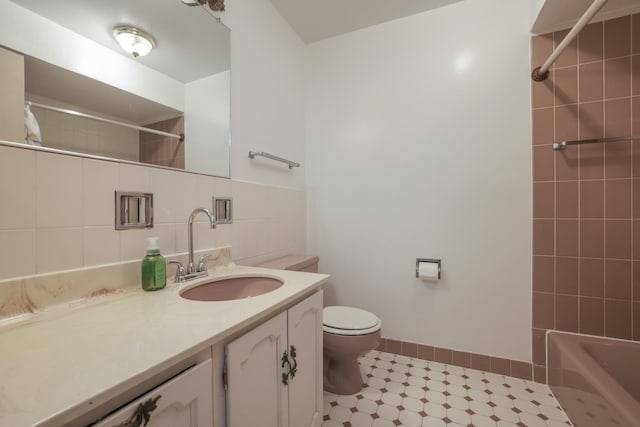 full bath featuring tile walls, shower / bath combination, backsplash, toilet, and vanity