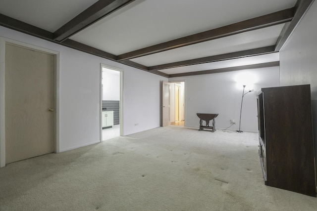 carpeted empty room with beamed ceiling