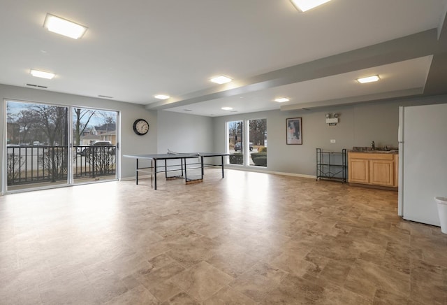 recreation room with visible vents, a sink, and baseboards