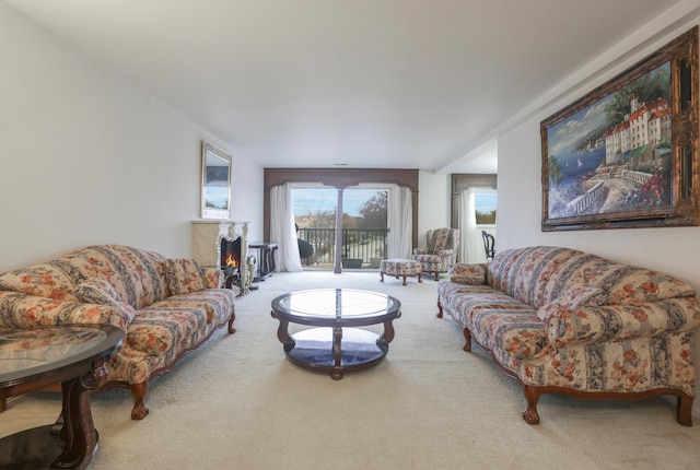 living room featuring carpet floors and a lit fireplace