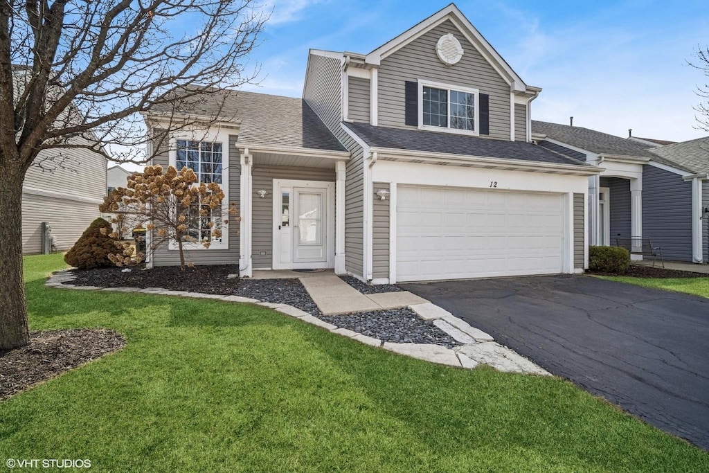 traditional-style home featuring aphalt driveway, a garage, a front yard, and roof with shingles