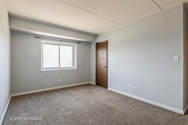 carpeted empty room with visible vents, baseboards, and a textured ceiling